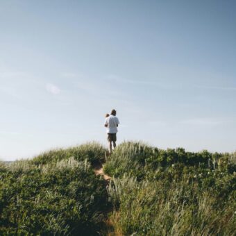 natalie-toombs-vteE6bVU7ic-unsplash Men standing among the grass contemplating the view